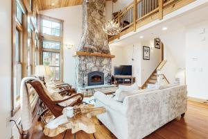 sala de estar con sofá y chimenea de piedra en Vermont Mountain Chalet, en Stratton