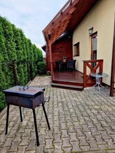 a patio with a table and a house at Linos Apartamentai in Druskininkai