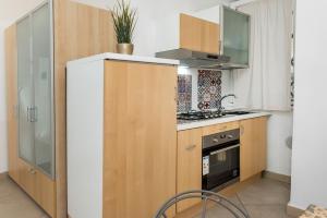 uma cozinha com armários de madeira e um forno com placa de fogão em A22 - Ancona, delizioso monolocale in pieno centro dx em Ancona