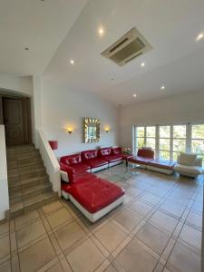 ein Wohnzimmer mit einem roten Sofa und Stühlen in der Unterkunft Villa avec piscine vue sur la mer in Cannes