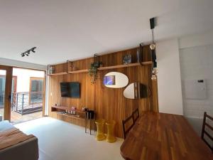 Vilage Villa Andorinha - apt 09 في موسوجي: غرفة معيشة مع طاولة طعام وتلفزيون