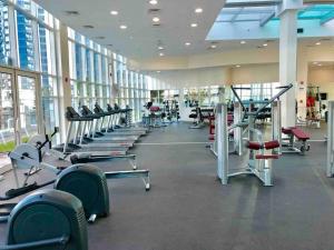 a gym with a row of treadms and machines at Lovely Private Contemporary Residential Apartment - 201 in Abu Dhabi