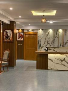 a lobby with a desk and a wooden door at Arya Hotel Islamabad in Islamabad