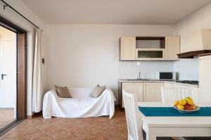 a kitchen with a table with a bowl of fruit on it at Bellosguardo 4 - Klodge in Olbia