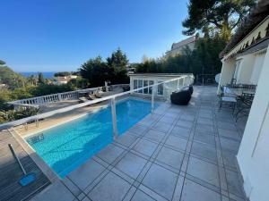 - une piscine sur une terrasse à côté d'une maison dans l'établissement Villa avec piscine vue sur la mer, à Cannes