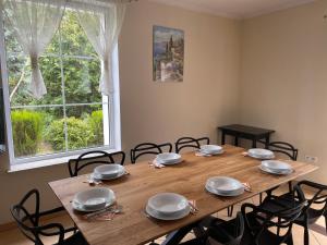 a dining room table with chairs and a large window at Zaczarowany Bieślin in Trzemeszno