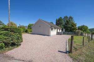 a house with a fence and a gravel driveway at Cuilreigh, North Connel in Oban