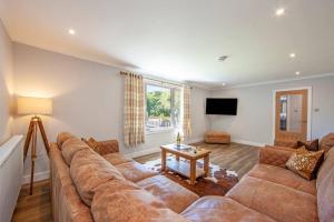 un soggiorno con un grande divano e una TV di Cuilreigh, North Connel a Oban