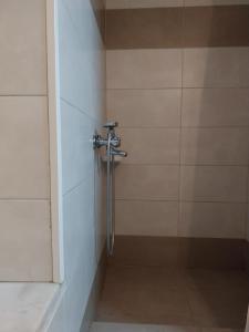 y baño con ducha y pared de azulejos. en HERMOUPOLI ROOMS, en Ermoupoli