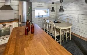 伊斯拉韋德的住宿－2 Bedroom Amazing Home In Gislaved，一间带木桌的厨房和一间餐厅