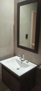 a bathroom with a white sink and a mirror at Las lilas in Zavalla
