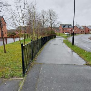 a sidewalk with a fence on the side of a street at Three Bedroom House in Runcorn By The Lake with Parking by Neofinixdotcom in Runcorn