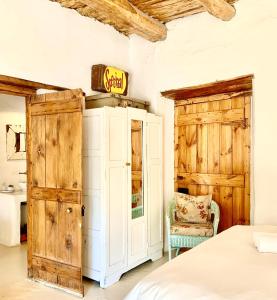 - une chambre avec un lit, une porte et une chaise dans l'établissement Brakdakkie Guest Cottages, à Prince Albert