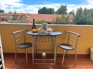 a table with two chairs and a bottle of wine on a balcony at Villaggio al mare in Manfredonia