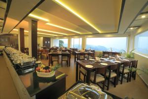 a dining room with tables and chairs in a restaurant at Munnar Tea Hills Resort - MTHR in Munnar