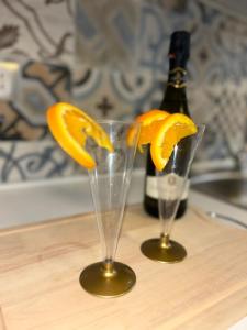 two glasses with orange slices in front of a bottle of wine at Villaggio al mare in Manfredonia