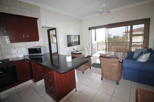 a kitchen with a counter top and a living room at Topanga 70, Uvongo in Margate