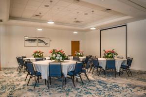 a conference room with tables and chairs and flowers at Maritime Hotel Fort Lauderdale Airport & Cruiseport in Fort Lauderdale