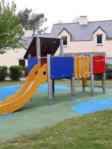 plac zabaw ze zjeżdżalnią w parku w obiekcie Les cottages du golf à Ploemel w mieście Ploemel
