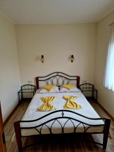 um quarto com uma cama grande e almofadas amarelas em Linos Apartamentai em Druskininkai