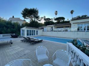 un patio avec des chaises et une piscine dans l'établissement Villa avec piscine vue sur la mer, à Cannes