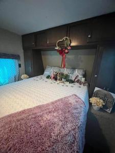 Brisas de Isabela Cozy Glamper 1 في إيزابيلا: غرفة نوم مع سرير مع لحاف وردي