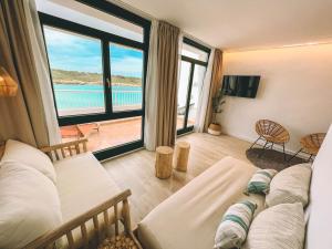 a living room with a couch and a view of the ocean at Beach Club Menorca in Son Parc