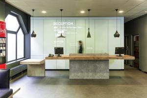 a person sitting at a reception desk in a library at ibis Gent Centrum Opera in Ghent