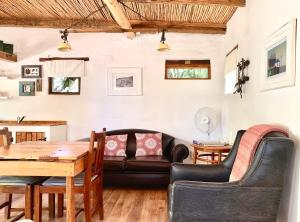 a living room with a table and a couch at Brakdakkie Guest Cottages in Prince Albert