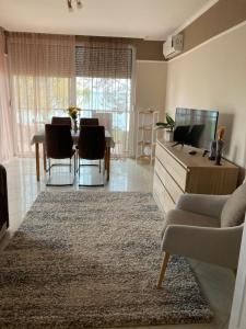 ein Wohnzimmer mit einem Sofa und einem Tisch mit Stühlen in der Unterkunft Gruber Apartman in Siófok