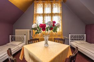 a vase of flowers on a table with two beds at Historic Villa "Imperia" in Prague