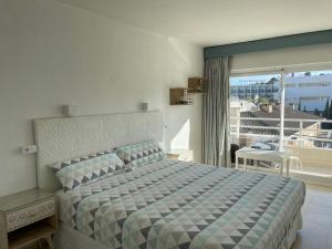 a bedroom with a bed with a view of a balcony at Hostal Roberto in Palmanova