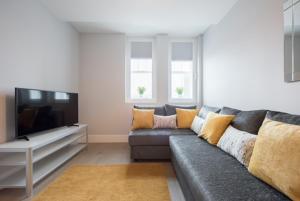 a living room with a couch and a flat screen tv at S/KING BED ONE BEDROOM FLAT in Brentwood