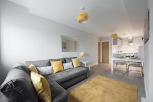 a living room with a gray couch and a kitchen at S/KING BED ONE BEDROOM FLAT in Brentwood