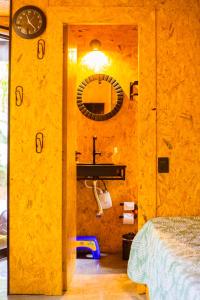 a bathroom with a yellow wall with a sink and a mirror at Cabana na Serra Gaúcha - Refúgio de São Chico in São Francisco de Paula