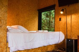 a bed in a room with a window at Cabana na Serra Gaúcha - Refúgio de São Chico in São Francisco de Paula