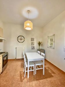 cocina y comedor con mesa blanca y sillas en Olive House Apartment Paros en Kampos Paros