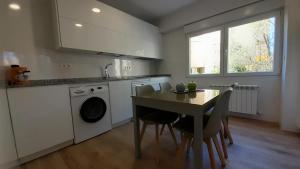a kitchen with a table and a washing machine at Apartamento Salamanca by Cloe in Salamanca
