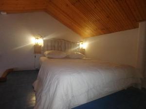 a bedroom with a white bed with two lights on it at Maison à La Palmyre, proche commerces et plages in Les Mathes