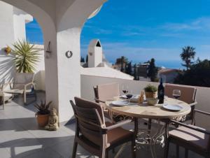 Una mesa y sillas en un balcón con vista al mar. en Beautiful apartment with amazing Sea view, en Nerja