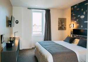 Postel nebo postele na pokoji v ubytování Hôtel Les Agapanthes-Logis Hôtel