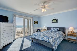 een slaapkamer met een bed en een balkon met uitzicht op de oceaan bij 110 N Permuda Wynd in North Topsail Beach