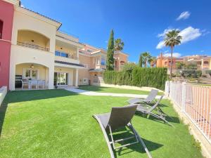 un patio con sillas de jardín y una casa en Soleada PBaja con Gran Terraza a pie de piscina Altaona Golf en Murcia