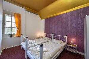布拉格的住宿－Historic Villa "Imperia"，卧室配有白色的床和紫色墙壁