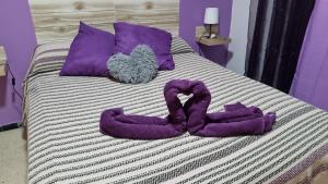 a pair of purple snakes sitting on top of a bed at vivienda Acerina in Las Palmas de Gran Canaria