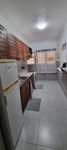 a large kitchen with wooden cabinets and white appliances at vivienda Acerina in Las Palmas de Gran Canaria