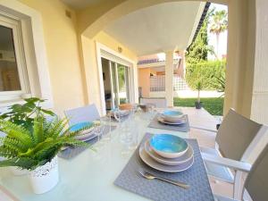 una mesa de comedor con platos y platos. en Soleada PBaja con Gran Terraza a pie de piscina Altaona Golf en Murcia