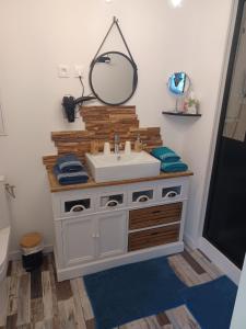 a bathroom with a sink and a mirror at Chambre d’hôtes des tourterelles in Champniers