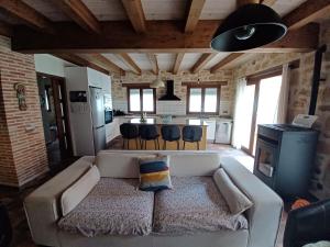 ein Wohnzimmer mit einem Sofa und einer Küche in der Unterkunft El Corral de Avelina in Valjunquera