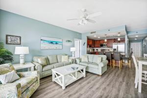 a living room with two couches and a table at Laketown Wharf #824 by Nautical Properties in Panama City Beach